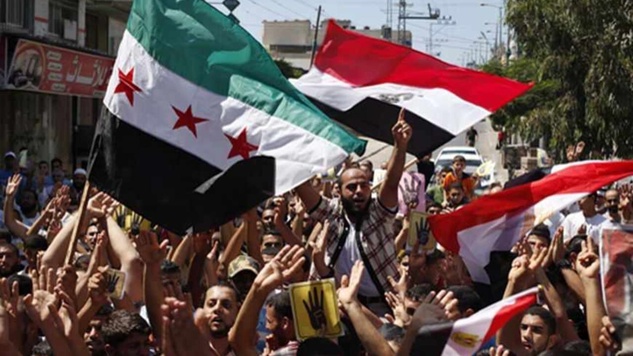 PALESTINIANS-EGYPT/ Palestinians chant slogans while waving Syrian opposition and Egyptian flags during a rally in support of Egypt's deposed Islamist President Mohamed Mursi and against Syria's President Bashar al-Assad in the central Gaza Strip August 23, 2013. REUTERS/Ibraheem Abu Mustafa (GAZA - Tags: POLITICS CIVIL UNREST) - RTX12U7U