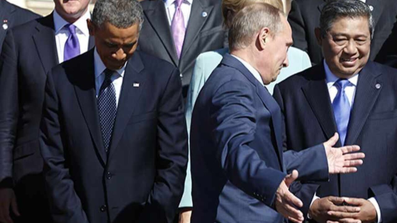RUSSIA-G20/ Russian President Vladimir Putin holds out his arms as he walks past U.S. President Barack Obama (L) during a group photo at the G20 Summit in St. Petersburg September 6, 2013. Above Obama is British Prime Minister David Cameron. At right is Indonesian President Susilo Bambang Yudhoyono. REUTERS/Kevin Lamarque (RUSSIA - Tags: BUSINESS POLITICS) - RTX139JC