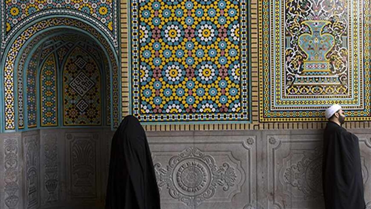 IRAN/ A cleric and a woman stand at an entrance to the shrine of Hazrat-e Massoumeh, granddaughter of Prophet Mohammad, in Qom, 120 km (75 miles) south of Tehran February 3, 2009. REUTERS/Caren Firouz (IRAN) - RTXB736