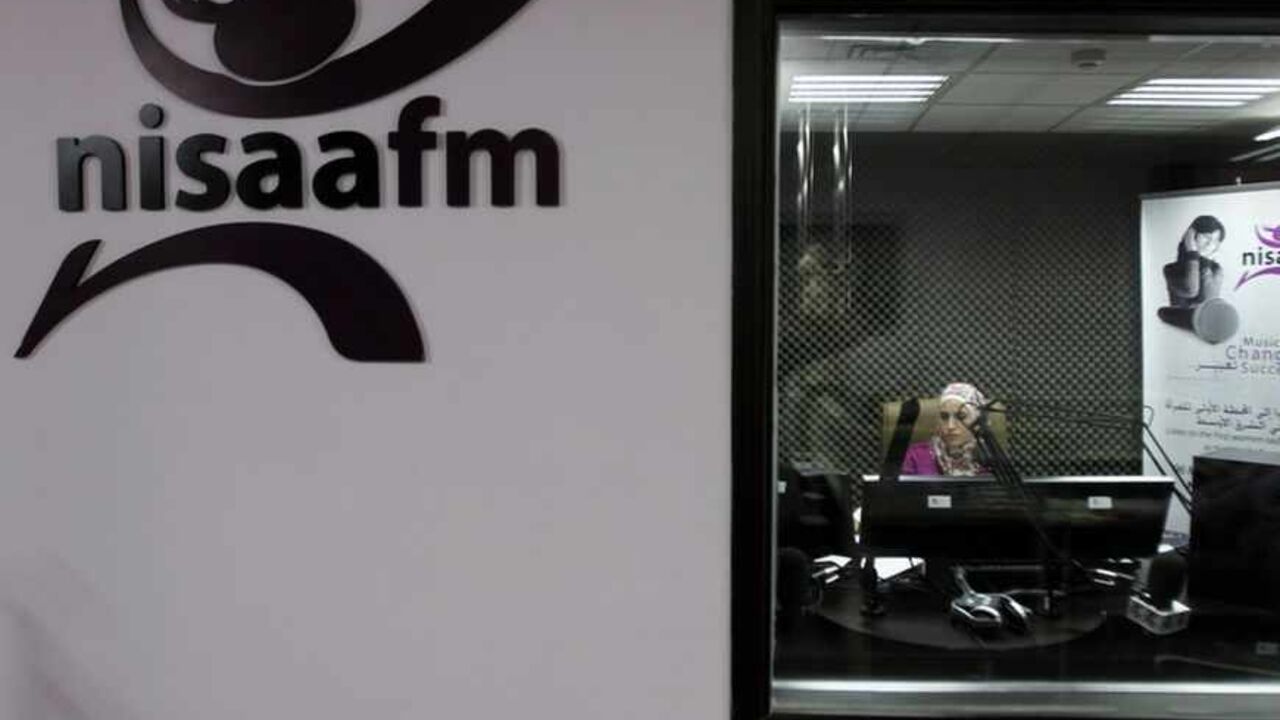 A radio broadcaster sits in the sound booth at NISAA FM radio station in Ramallah A radio broadcaster sits in the sound booth at NISAA FM radio station in the West Bank city of Ramallah July 9, 2012. Looking to spread the good word, NISAA FM radio station took to the airwaves in 2010, set up by and for women. It highlights local success stories about anything from female-led investment groups to refugee camp microfinance projects. Picture taken July 9, 2012. To match story PALESTINIAN-BUSINESS/WOMEN REUTERS/Mohamad Torokman (WEST BANK - Tags: BUSINESS MEDIA) - RTR34TV0