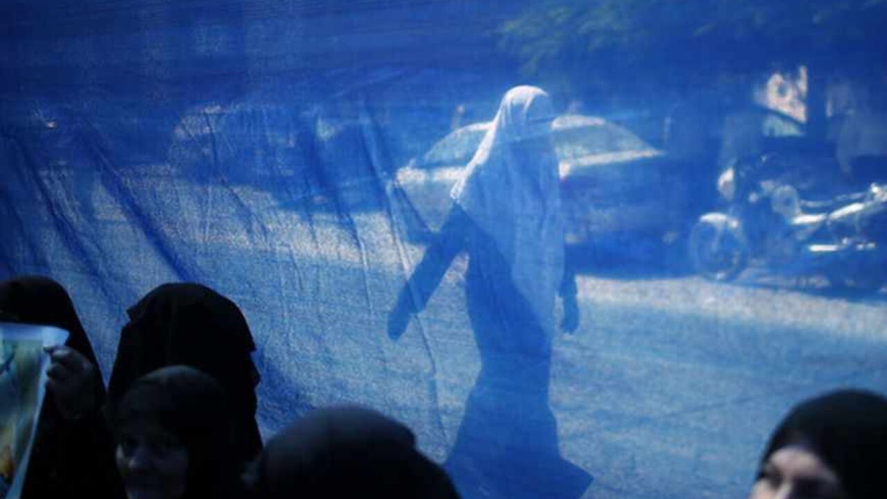 Woman is seen through a fabric sheet as she walks past a rally calling for the release of Palestinian prisoners from Israeli jails, in Gaza City A woman is seen through a fabric sheet as she walks past a rally calling for the release of Palestinian prisoners from Israeli jails, in Gaza City September 2, 2013. REUTERS/Mohammed Salem (GAZA - Tags: POLITICS CIVIL UNREST) - RTX134LM