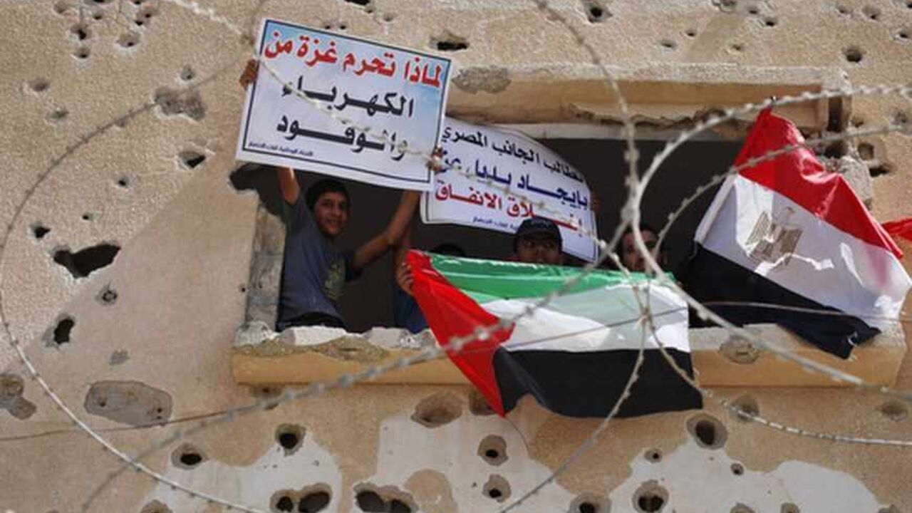 Palestinians wave flags as they take part in a rally calling on Egyptian authorities to open the Rafah crossing in the southern Gaza Strip Palestinians wave a national flag and an Egyptian flag (R) as they take part in a rally calling on Egyptian authorities to open the Rafah crossing, outside the crossing in the southern Gaza Strip September 16, 2013. Cairo closed the Rafah crossing, Gaza's main window to the world, completely last week after assailants crashed two explosive-laden cars into a security building adjacent to the border zone, killing six Egyptian soldiers. Ashraf al-Qidra, spokesman for the Hamas-run Gaza Health Ministry, said 1,