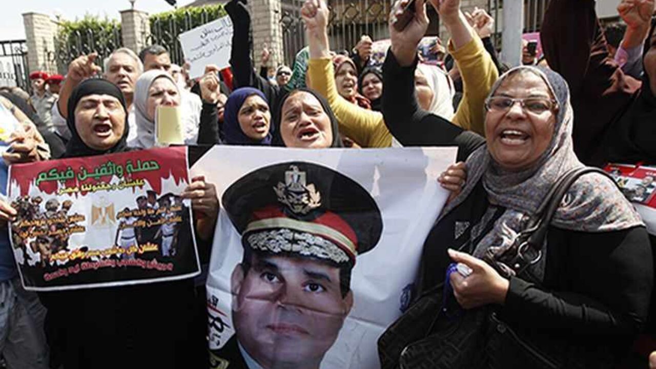EGYPT-SECURITY/ Mourners hold a poster of Army Chief General Abdel Fattah al-Sisi during the military funeral service of police General Nabil Farag, who was killed on Thursday in Kerdasa, in Cairo's Nasr City district September 20, 2013. Egyptian security forces were hunting for supporters of deposed President Mohamed Mursi of the Muslim Brotherhood on Friday after retaking control of the town near Cairo in a crackdown on Islamists. On Thursday, army and police forces stormed Kerdasa where Islamist sympathies run deep and