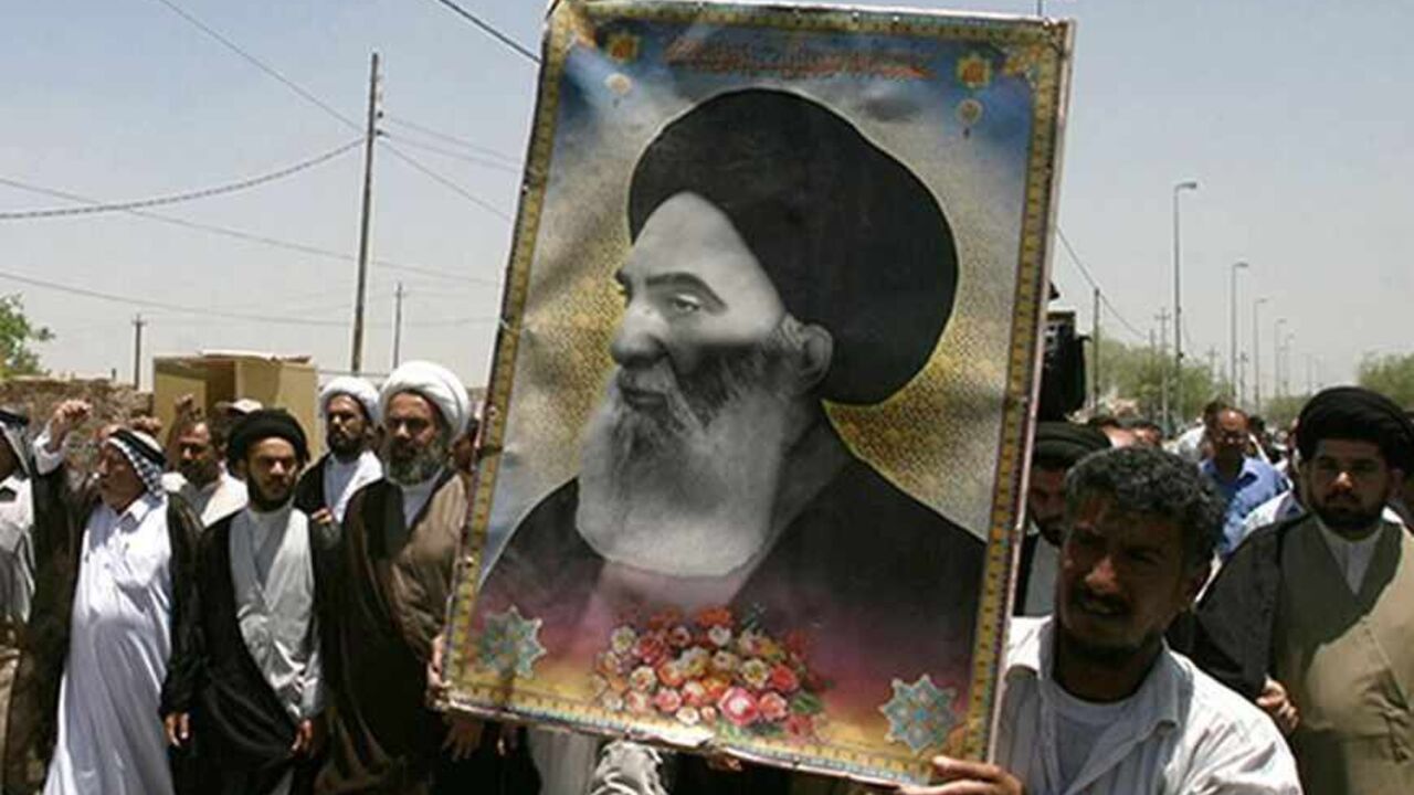 IRAQ/ Iraqis carry a poster of top Shi'ite cleric Grand Ayatollah Ali al-Sistani during a demonstration in Najaf, 160 km (100 miles) south of Baghdad June 13, 2007. Dozens of residents took to the streets in Najaf protesting the latest bomb attack in Samarra's Golden Mosque Shi'ite shrine. REUTERS/Ali Abu Shish (IRAQ) - RTR1QQY3