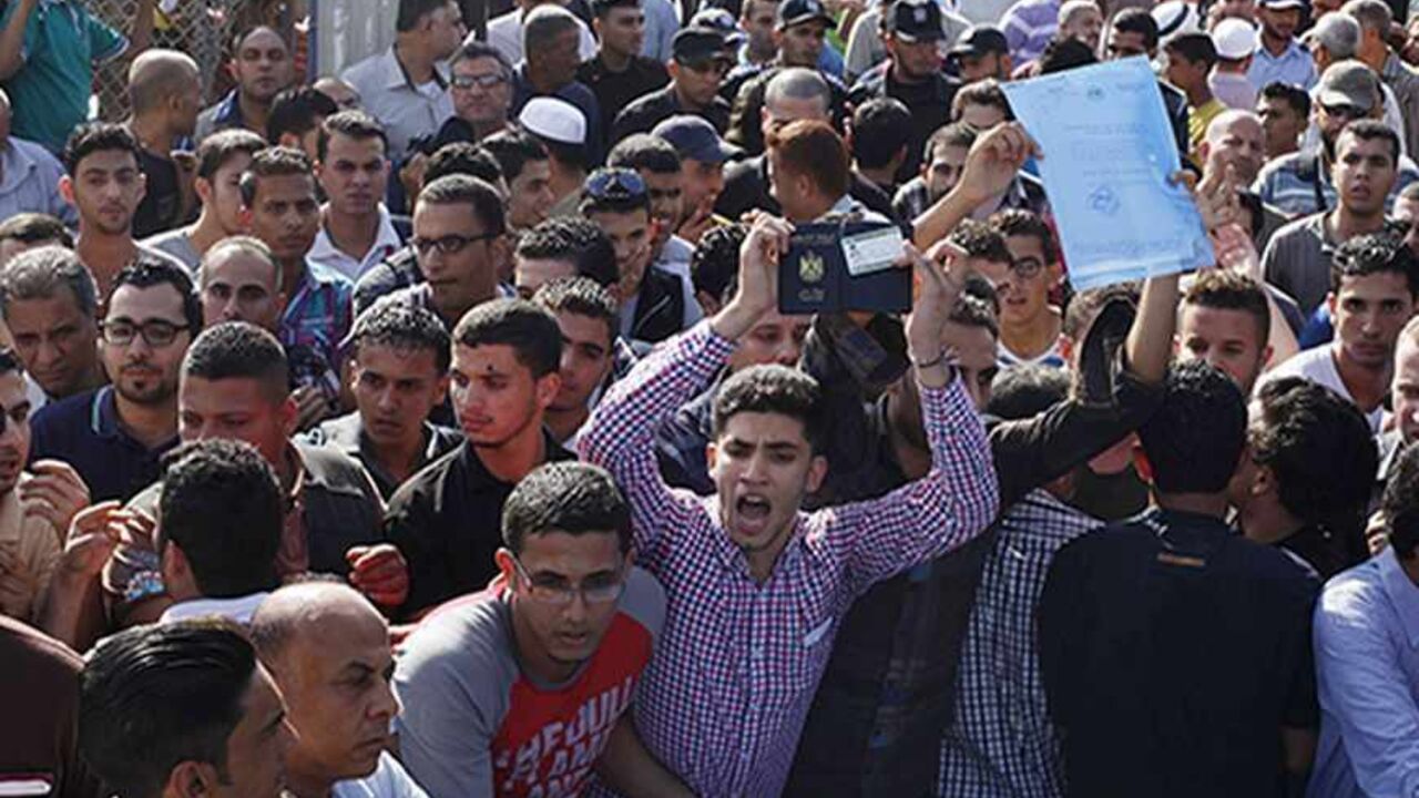 PALESTINIANS-EGYPT/ Passengers gather around the gate of Rafah crossing with Egypt as they protest against the conditions on the crossing, with hopes of crossing into Egypt, September 18, 2013. Egypt partially reopened its border crossing with the Gaza Strip on Wednesday, a week after it was closed in response to a deadly attack on an Egyptian military headquarters near the frontier. Officials of the Palestinian Authority, the West Bank-based rival of Gaza's Hamas Islamist rulers, said Cairo agreed to open the crossing for fou