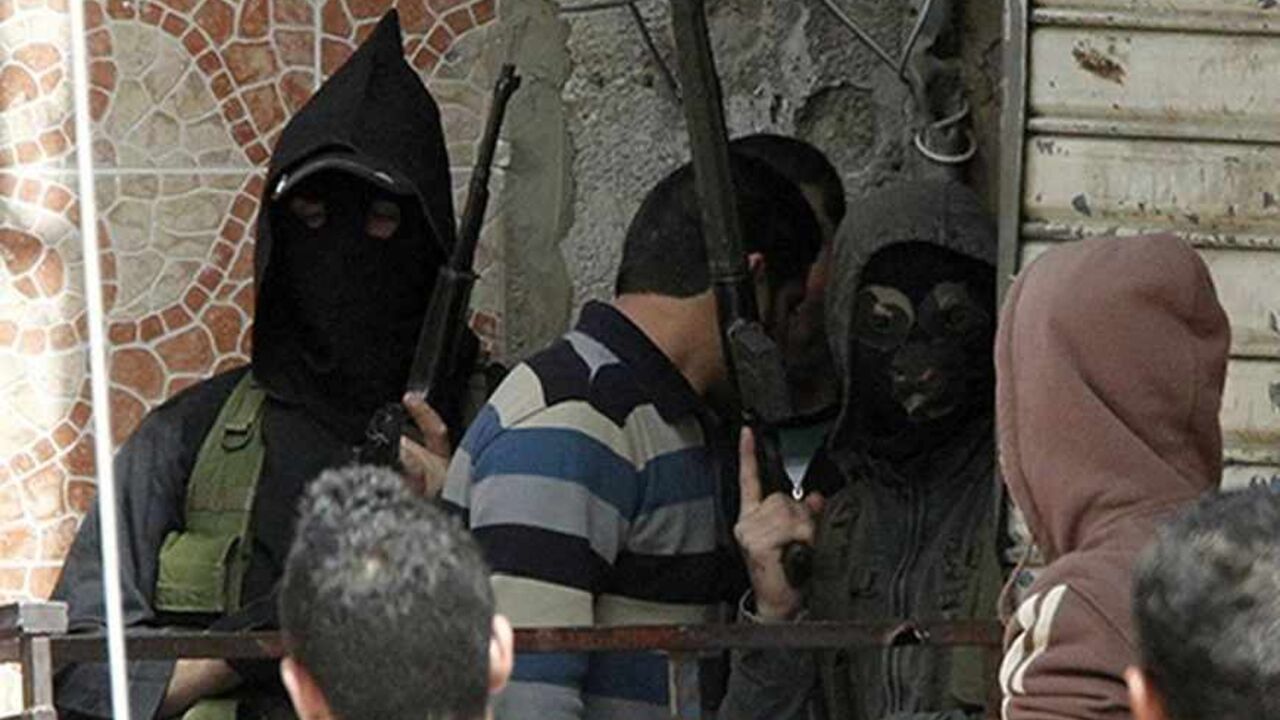 Two masked gunmen stand with their weapons at Ain al-Hilweh Palestinian refugee camp near the port city of Sidon in south Lebanon, March 12, 2013. Ten people were wounded and one killed during clashes between Fatah movement and radical Islamists that started on Monday.  REUTERS/Ali Hashisho (LEBANON - Tags: POLITICS CIVIL UNREST) - RTR3EW3P