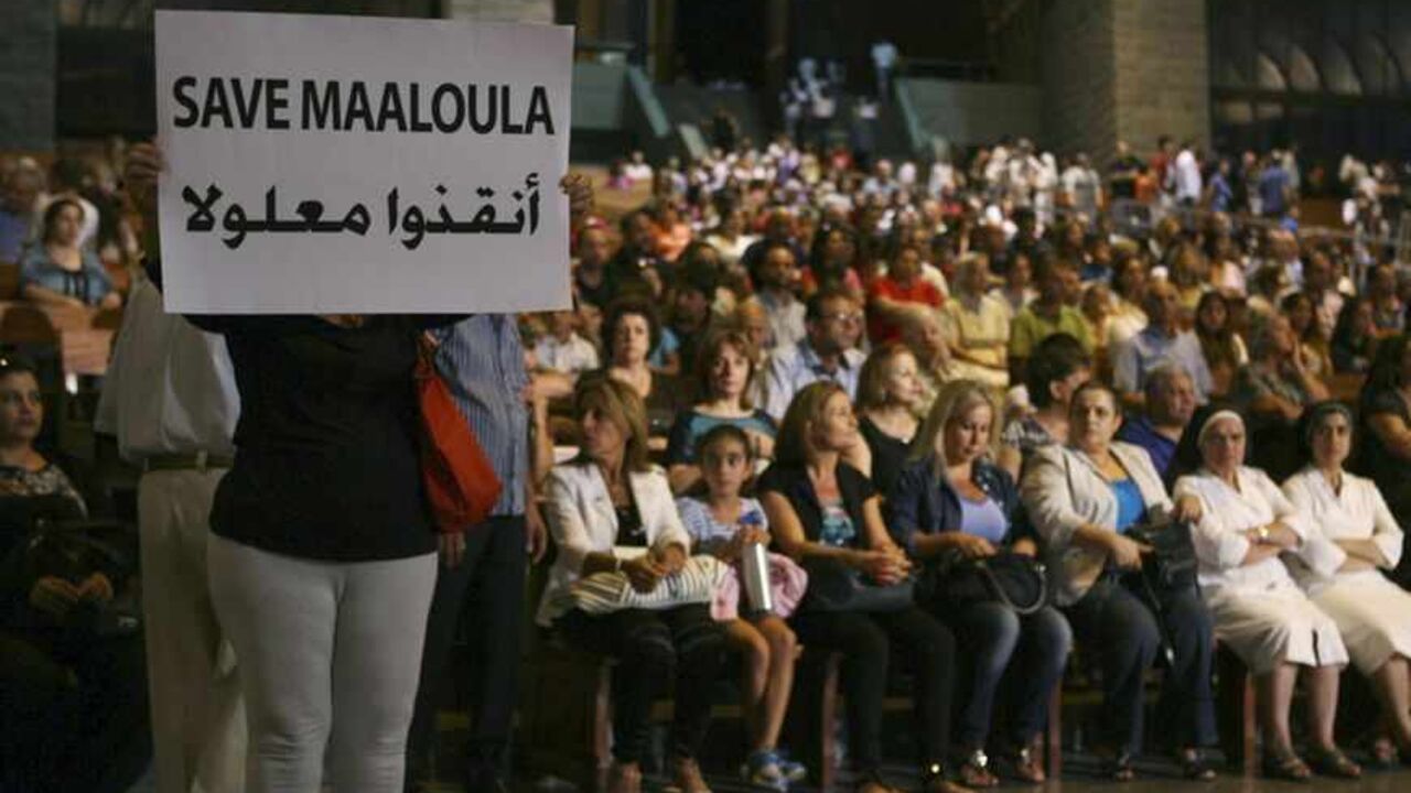 A Syrian woman holds a banner for saving Maaloula while Lebanese and Syrian Christian Maronites pray for peace in Syria, in Harisa, Jounieh A Syrian woman holds a banner for saving Maaloula while Lebanese and Syrian Christian Maronites pray for peace in Syria, in Harisa, Jounieh September 7, 2013. REUTERS/Hasan Shaaban (LEBANON - Tags: POLITICS RELIGION) - RTX13C2S