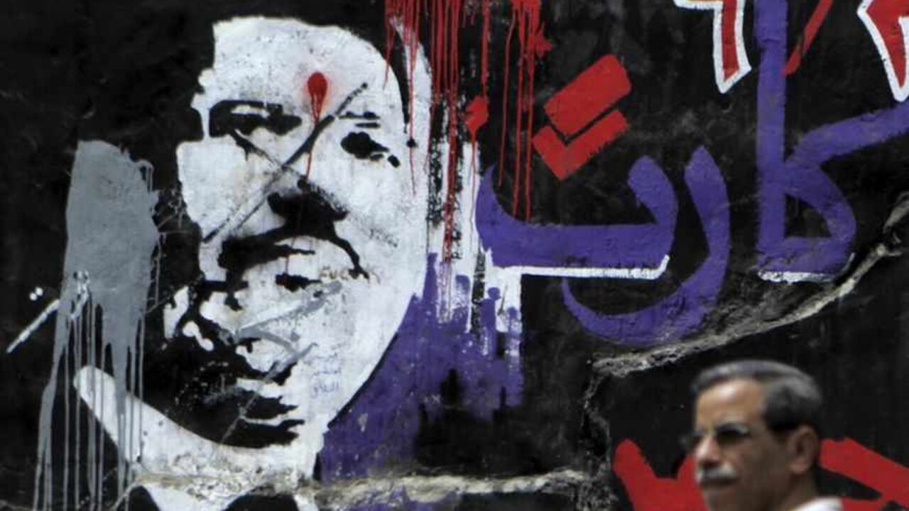 A man walks past graffiti depicting ousted Egyptian President Mursi in downtown Cairo A man walks past graffiti depicting ousted Egyptian President Mohamed Mursi in downtown Cairo September 2, 2013. Egypt's army-backed authorities referred deposed Mursi to trial on Sunday on charges of inciting murder and violence, in an escalation of the crackdown on his Muslim Brotherhood. The Arabic words read: "Red card, 30 June" REUTERS/Amr Abdallah Dalsh (EGYPT - Tags: POLITICS CIVIL UNREST) - RTX134KT