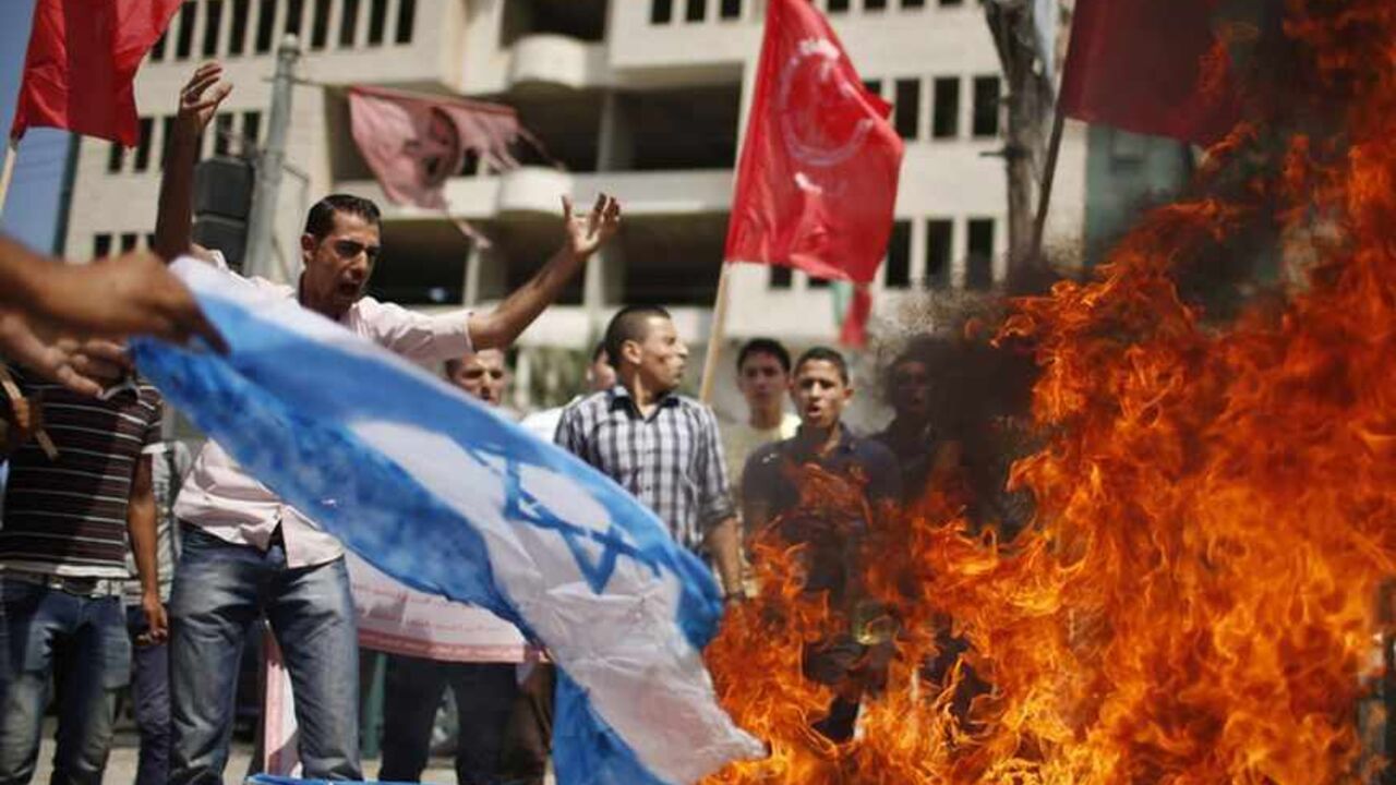 Supporters of Palestinian leftist parties burn a replica Israeli flag during a rally in Gaza City Supporters of Palestinian leftist parties burn a replica Israeli flag during a rally calling for the cancellation of the Oslo peace agreement and the end of the latest round of peace talks with Israel in Gaza City September 15, 2013. The Oslo peace accord was signed by the Palestinian Liberation Organisation (PLO) and Israel in 1993 and was meant to pave the way to a permanent peace between the Palestinians and Israel. REUTERS/Mohammed Salem (GAZA - Tags: POLITICS CIVIL UNREST) - RTX13LZB