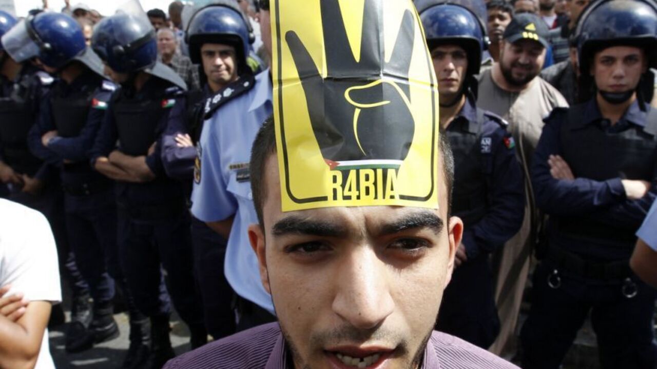 A supporter of Jordan's opposition parties wearing a sign on his forehead shouts slogans during a demonstration after Friday prayers in Amman A supporter of Jordan's opposition parties wearing a sign on his forehead shouts slogans demanding freedom for political prisoners, political and economic reforms, and access to government corruption cases during a demonstration after Friday prayers in Amman October 4, 2013. Anti-government protesters across the region have been using the four-fingered salute on a yellow background, which represents those who were killed in Cairo's al-Rabia Square in Egypt in August, as a tacit statement of opposition to th