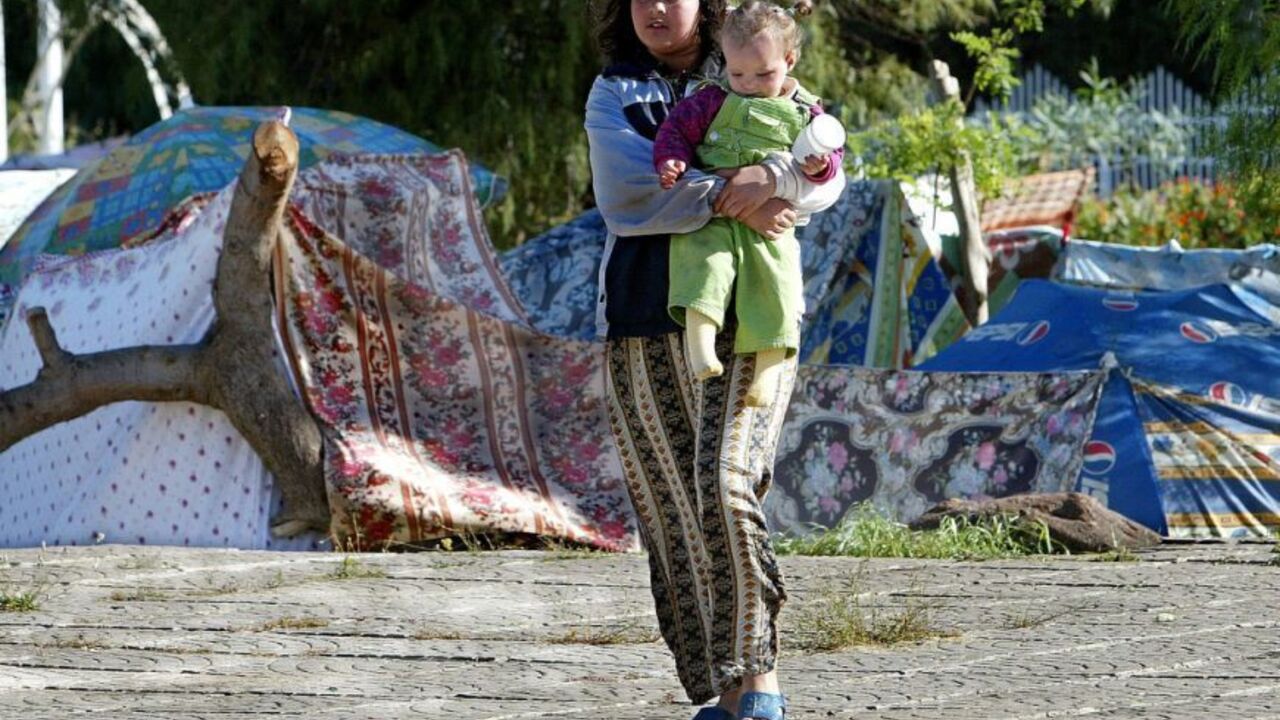 An Algerian girl holding a baby walks past makeshift shelters May 24, 2003 in the Algerian town of B.. An Algerian girl holding a baby walks past makeshift shelters May 24, 2003 in the Algerian town of Boumerdes after an earthquake hit Algeria's Mediterranean coast three days ago. Hopes dwindled on Saturday of finding survivors three days after the worst earthquake in Algeria for more than two decades killed more than 1,750 people. - RTXLZF6