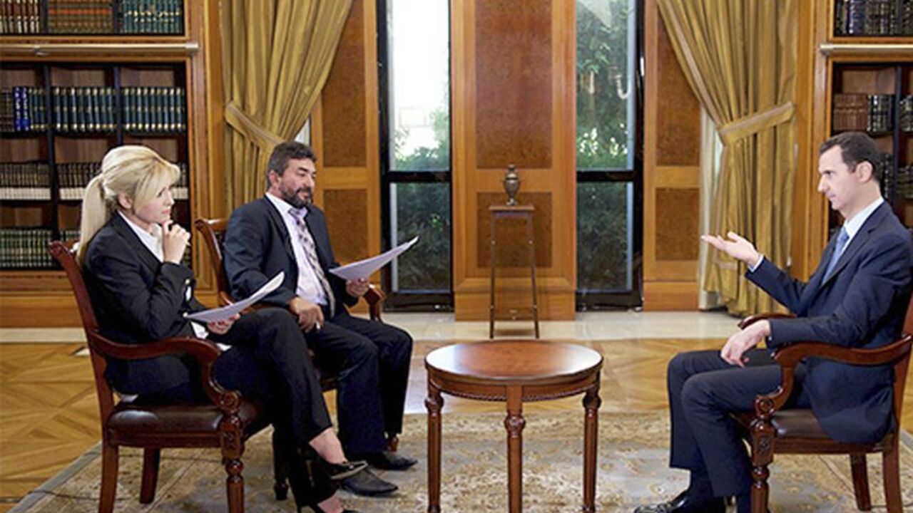SYRIA-CRISIS/ASSAD-TURKEY Syria's President Bashar al-Assad (R) speaks during an interview with Turkey's Halk TV in Damascus, in this handout photograph distributed by Syria's national news agency SANA on October 4, 2013. Assad has told Turkey it will pay a heavy price for backing rebels fighting to oust him, accusing it of harbouring "terrorists" along its border who would soon turn against their hosts. In an interview with Turkey's Halk TV due to be broadcast later on Friday, Assad called Turkish Prime Minister Tayyip Erdogan "big