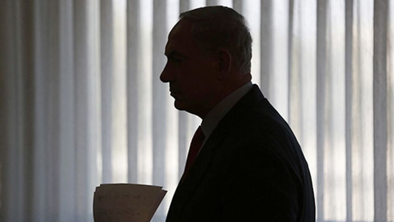 PALESTINIANS-ISRAEL/ Israeli Prime Minister Benjamin Netanyahu is silhouetted as he arrives to deliver a statement to the media at the Knesset, Israeli parliament, in Jerusalem July 22, 2013. Netanyahu will seek formal cabinet backing for reviving U.S.-sponsored peace talks with the Palestinians, an Israeli official said, after pro-settler ministers threatened to try and thwart the initiative. REUTERS/Baz Ratner (JERUSALEM - Tags: POLITICS) - RTX11V4Y