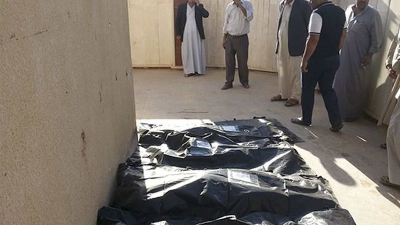 IRAQ-VIOLENCE/ Civilians look at the bodies of victims of an attack in the village of Mwafaqiya, in Nineveh province, October 17, 2013. A suicide bomber driving a truck packed with explosives blew himself up in a village in northern Iraq, killing at least 11 people early on Thursday, police said. The attack targeted members of Iraq's predominantly Shi'ite Shabak minority in the village of Mwafaqiya in Nineveh province. REUTERS/Stringer (IRAQ - Tags: CIVIL UNREST POLITICS) - RTX14F5M