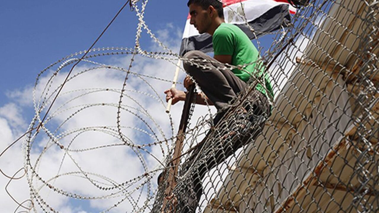 PALESTINIANS-EGYPT/GAZA A Palestinian youth waves an Egyptian flag as he takes part in a rally calling on Egyptian authorities to open the Rafah crossing, outside the crossing in the southern Gaza Strip September 16, 2013. Cairo closed the Rafah crossing, Gaza's main window to the world, completely last week after assailants crashed two explosive-laden cars into a security building adjacent to the border zone, killing six Egyptian soldiers. Ashraf al-Qidra, spokesman for the Hamas-run Gaza Health Ministry, said 1,000 patients a mo