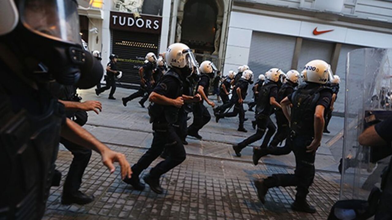 TURKEY-PROTESTS/POLICE Riot police officers run after demonstrators on Istiklal Street in central Istanbul July 13, 2013. Turkish police fired water cannon and tear gas on Saturday to disperse hundreds of protesters who gathered to march to Gezi Park, which has been at the heart of fierce unrest against Prime Minister Erdogan's rule. Protesters scattered, running into sidestreets where police pursued them, before starting to regroup on Istiklal Street, metres from the main Taksim Square. REUTERS/Umit Bektas (TURKEY - Tags: POLITI