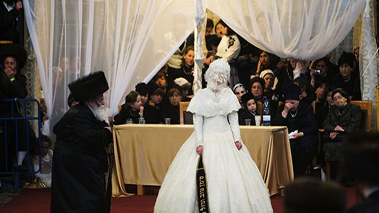 ISRAEL/ Ultra-Orthodox Jewish bride Hannah Batya Penet dances with her relative during a wedding ceremony in Jerusalem, early morning May 22, 2013. Some 25,000 people gathered to celebrate the wedding of Penet to Shalom Rokeach, the eldest grandson of the Chief Rabbi of Belz, Yissachar Dov Rokeach, according to local media. The Belz Hasidic dynasty is one of the largest Hasidic movements in the world. REUTERS/Ronen Zvulun (JERUSALEM - Tags: RELIGION SOCIETY TPX IMAGES OF THE DAY) - RTXZWCC