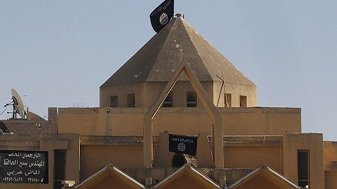 SYRIA-CRISIS/ Flags of the al-Qaeda linked Islamic State of Iraq and the Levant are hung on The Martyrs Church in Raqqa city centre September 27, 2013. The Al-Qaeda linked Islamic State of Iraq and the Levant removed crosses from The Martyrs Church in Raqqa and hoisted their flags on Thursday, activists say. REUTERS/Stringer (SYRIA - Tags: RELIGION CIVIL UNREST CONFLICT) - RTX14223