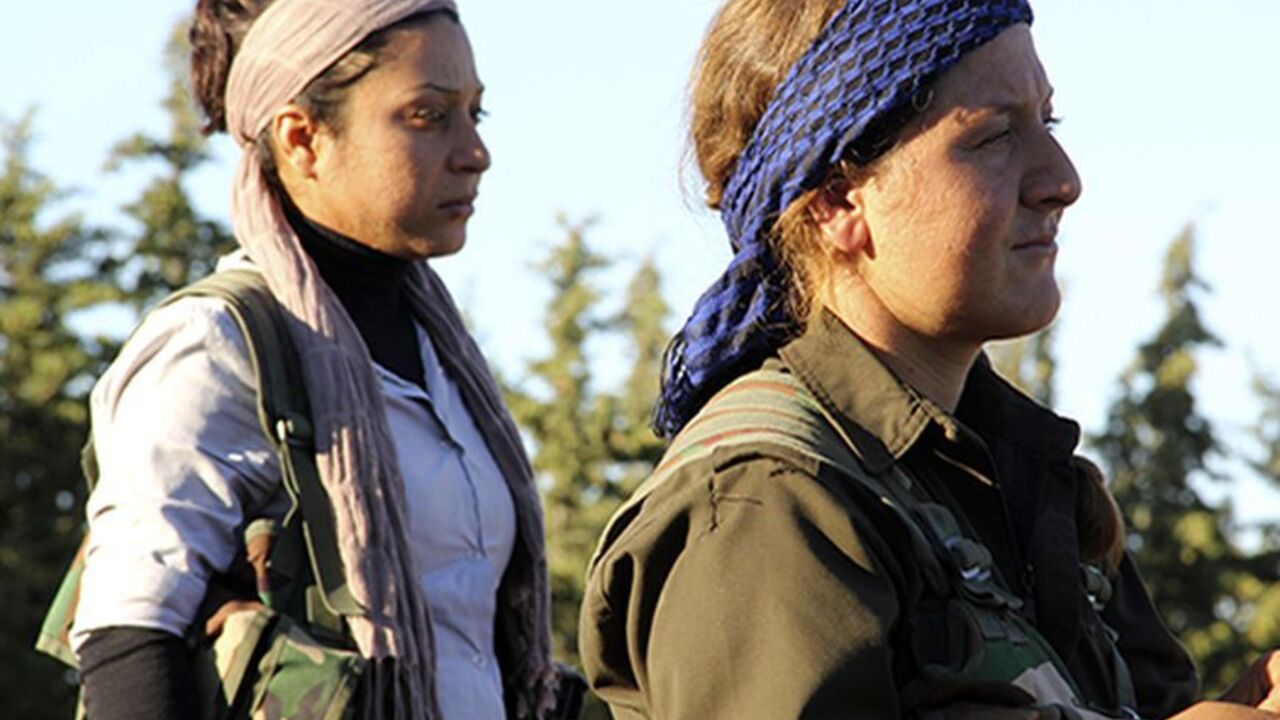 SYRIA-CRISIS/ Kurdish female fighters from the Popular Protection Units (YPG) watch their fellow fighters in the Kurdish town of Ifrin, in Aleppo's countryside October 14, 2013. Kurds comprise around 10 percent of Syria's 23 million population. They are concentrated in Ifrin and other areas of the northwest, in parts of Damascus and in the northeastern oil producing area of Qamishli, where there has also been intense fighting between Kurds and al-Qaeda linked Islamic State of Iraq and the Levant fighters. Picture taken O