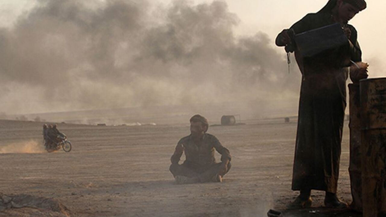 SYRIA/ A man works at a makeshift oil refinery site in al-Mansoura village in Raqqa's countryside May 5, 2013. Many civilians in the village who lost their jobs due to the Syrian conflict are making a living by refining crude oil to extract useful fuel such as gasoline and kerosene for sale. Picture taken May 5, 2013. REUTERS/Hamid Khatib (SYRIA - Tags: CONFLICT ENERGY BUSINESS EMPLOYMENT) - RTXZIAB