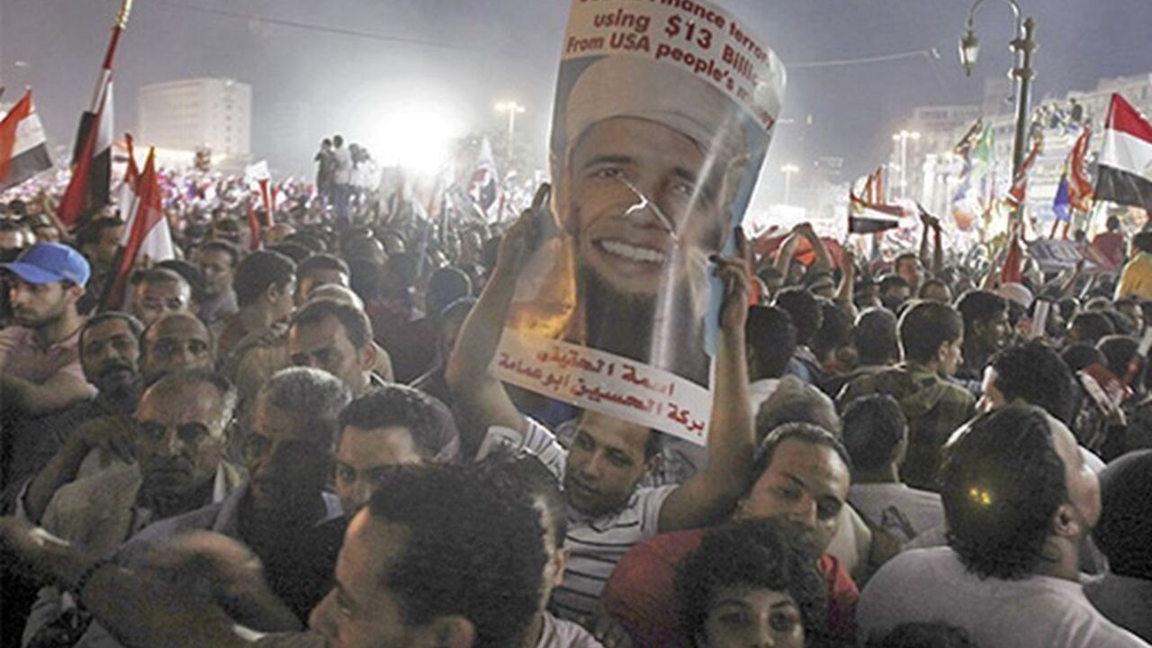 EGYPT-PROTESTS/FUTURE Anti-Mursi protesters cheer and hold up a poster depicting U.S. president Barack Obama with a beard at Tahrir square, where protesters gathered for a mass protest to support the army, in Cairo, July 26, 2013. Egypt's army is recasting the country's political drama, giving popular army chief Abdel Fattah al-Sisi the starring role in a change with echoes of the past that could undermine democracy in the Arab world. Picture taken July 26, 2013. REUTERS/Amr Abdallah Dalsh (EGYPT - Tags: POLITICS CIVIL UNREST M