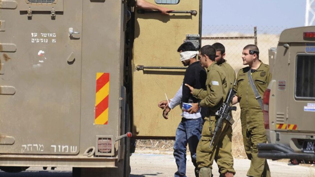 ISRAEL-PALESTINIANS/ATTACK Israeli soldiers detain a Palestinian close to the scene where Sariya Ofer, a retired Israeli army officer was killed in the West Bank Jewish settlement of Brosh Habika in the Jordan Valley October 11, 2013. Ofer was killed and his wife injured in what appeared to be an attack by Palestinian militants in the occupied West Bank, Israeli officials said on Friday. Israeli government ministers branded it a terror attack and some urged Prime Minister Benjamin Netanyahu to pull out of peace talks with the Palesti