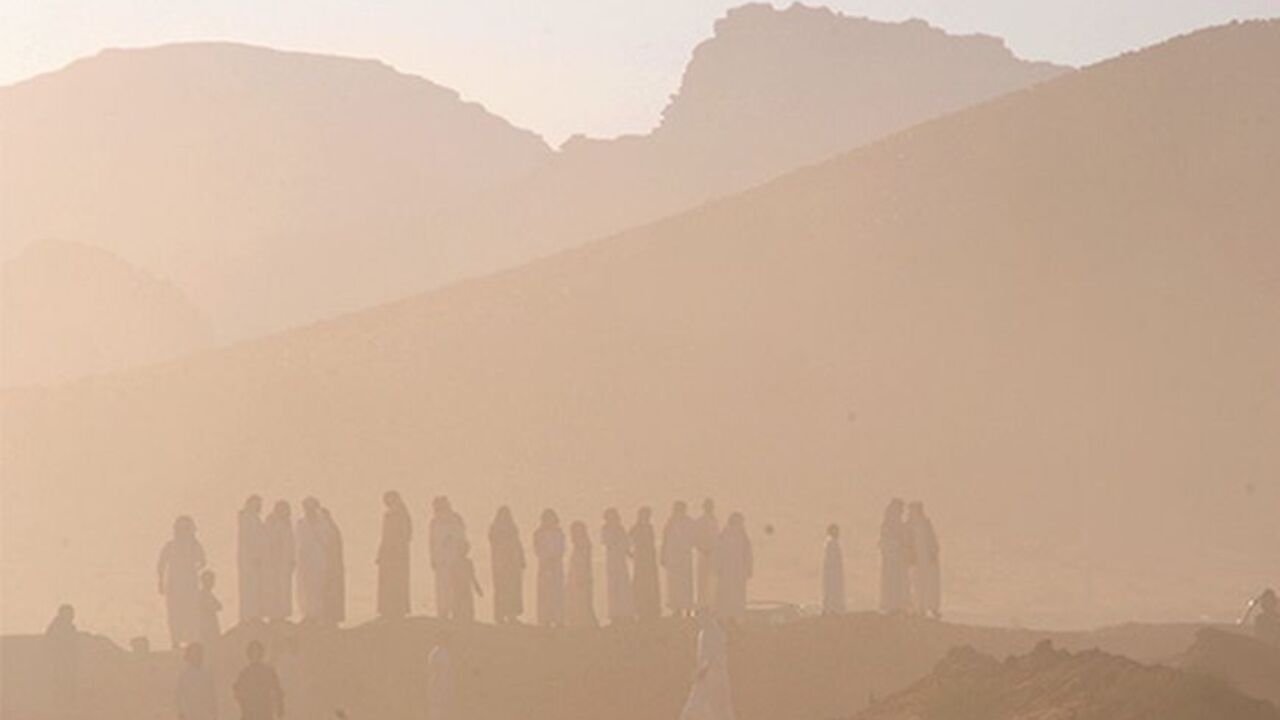 SAUDI/ Heavy dust is seen as people wait for contestants during a camel race, an annual event organised for desert dwellers, in the desert of Aleghan, north of Saudi Arabia, in Tabuk June 18, 2013. REUTERS/Mohamed Al Hwaity (SAUDI ARABIA - Tags: SOCIETY TPX IMAGES OF THE DAY) - RTX10RVW