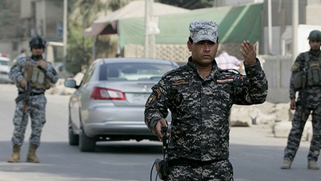 IRAQ-BAGHDAD/ Policemen operate a checkpoint in Baghdad October 17, 2011. As U.S. troops prepare to withdraw from Iraq, Baghdad security officials believe Iraqi forces are now more capable of containing violence, and plan to steadily cut back on checkpoints by around 50 percent and remove the blast walls in the city by the beginning of next year before reviewing the security situation again. Picture taken October 17, 2011. To match feature IRAQ-BAGHDAD/ REUTERS/Mahmoud Raouf Mahmoud (IRAQ - Tags: CIVIL UNREST