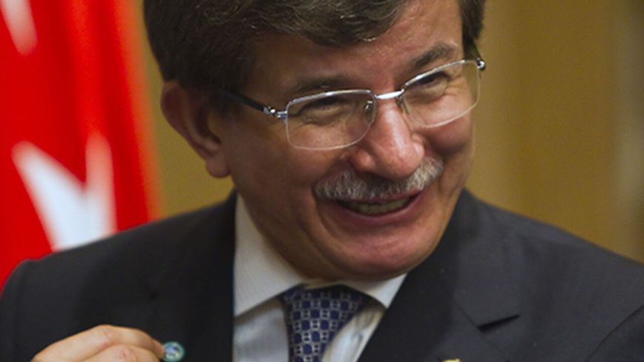 KAZAKHSTAN/ Turkey's Foreign Minister Ahmet Davutoglu shows a Shanghai Cooperation Organisation (SCO) pin after a signing ceremony granting Turkey a partner status in SCO, in Almaty April 26, 2013. REUTERS/Shamil Zhumatov (KAZAKHSTAN - Tags: POLITICS BUSINESS) - RTXZ0SB