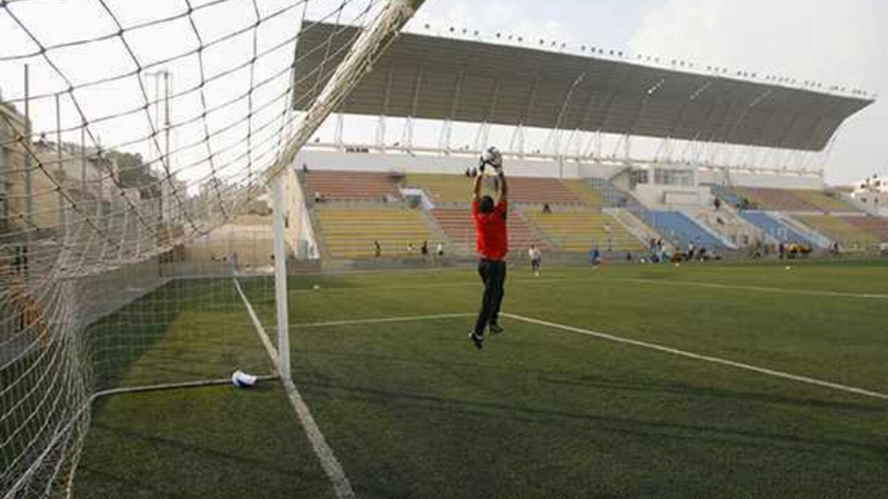 SOCCER-PALESTINE/ A Palestinian national team goalkeeper catches the ball during a warm-up before a local friendly soccer match at a stadium in al-Ram, on the edge of Jerusalem October 22, 2008. The Palestinian national team will play its first match on home soil on Sunday when they host Jordan in an international friendly at a new stadium near Jerusalem, the Palestinian FA chairman Jibril Rajoub said. Picture taken October 22, 2008. REUTERS/Fadi Arouri (JERUSALEM) - RTX9UN9
