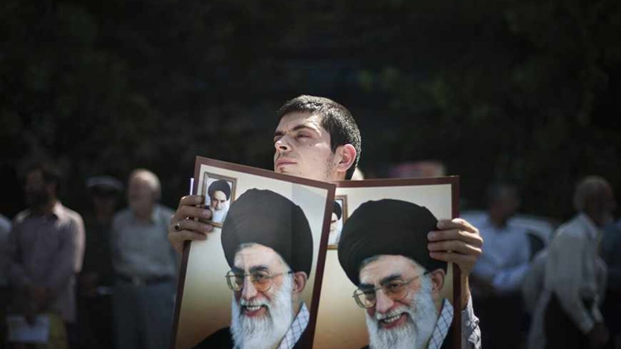 IRAN/ EDITORS' NOTE: Reuters and other foreign media are subject to Iranian restrictions on their ability to film or take pictures in Tehran.
An Iranian worshipper holds portraits of Iran's Supreme Leader Ayatollah Ali Khamenei while attending a demonstration to support the people of Bahrain after Friday prayers in Tehran September 9, 2011. REUTERS/Morteza Nikoubazl (IRAN - Tags: POLITICS CIVIL UNREST RELIGION TPX IMAGES OF THE DAY) - RTR2R0B3