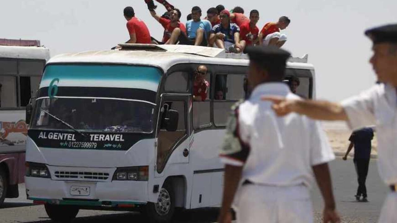Ultras, or hardcore fans, of Egypt's Al Ahly sit atop a bus as riot police cordon off the road before the derby CAF Champions League soccer match between Egypt's Zamalek and Al Ahly in Hurghada Ultras, or hardcore fans, of Egypt's Al Ahly sit atop a bus as riot police cordon off the road in front of the buses of Ultras before the derby CAF Champions League soccer match between Egypt's Zamalek and Al Ahly at El-Gouna stadium in Hurghada, about 464 km (288 miles) from the capital Cairo July 24, 2013. REUTERS/Amr Abdallah Dalsh (EGYPT - Tags: SPORT SOCCER CIVIL UNREST) - RTX11WZG