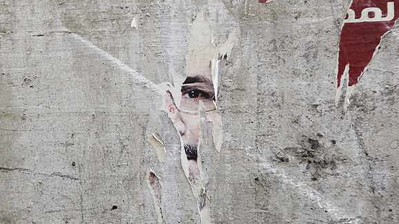 EGYPT-PROTESTS/ Remnants of a poster of ousted Egyptian President Mohamed Mursi are pictured on a wall on a street in Cairo August 25, 2013. Egypt's army-backed government shortened a night-time curfew by two hours on Saturday, 10 days after imposing it during a fierce crackdown on Muslim Brotherhood protesters in Cairo. Authorities imposed the curfew on August 14 when police destroyed Brotherhood protest camps in Cairo set up to demand the reinstatement of Mursi. REUTERS/Muhammad Hamed (EGYPT - Tags: POLITICS TPX IMAGES O