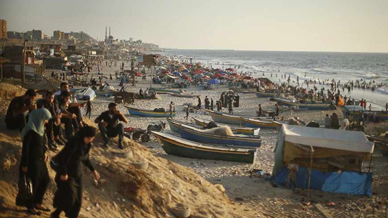 PALESTINIANS-BEACH/ Palestinians enjoy the weather on the beach in Gaza City August 23, 2013. Gaza's sandy beach is a favourite spot for locals to relax, especially as most residents cannot afford holidays outside the enclave. Picture taken August 23, 2013. REUTERS/Mohammed Salem (GAZA - Tags: POLITICS SOCIETY TPX IMAGES OF THE DAY) - RTX145VO