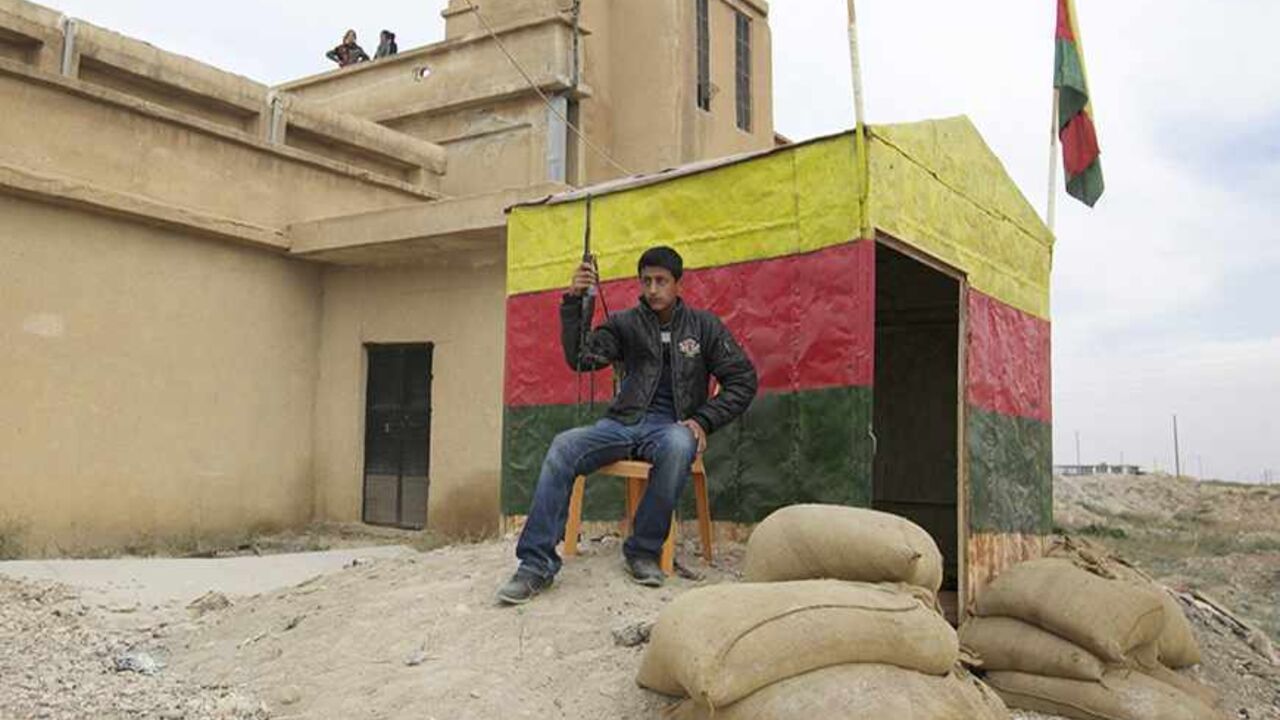 SYRIA-CRISIS/KURDS A member of the Kurdish People's Protection Units (YPG) carries his weapon as he sits at a checkpoint near the city of Ras al-Ain November 5, 2013. Redur Xelil, spokesman for the armed wing of the Syrian Kurdish Democratic Union Party (PYD), said Kurdish militias had seized the city of Ras al-Ain and all its surrounding villages. Syrian Kurdish fighters have captured more territory from Islamist rebels in northeastern Syria, a Kurdish militant group said on Monday, tightening their grip on an area where the