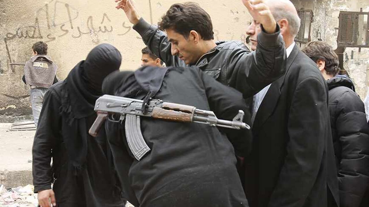 Fighters from the Islamist Syrian rebel group Jabhat al-Nusra search civilians at the Karaj al-Hajez crossing, a passageway separating Aleppo's Bustan al-Qasr, which is under the rebels' control, and Al-Masharqa neighbourhoods, an area controlled by the regime November 7, 2013. REUTERS/ Ammar Abdullah   (SYRIA - Tags: POLITICS CIVIL UNREST CONFLICT) - RTX153YY