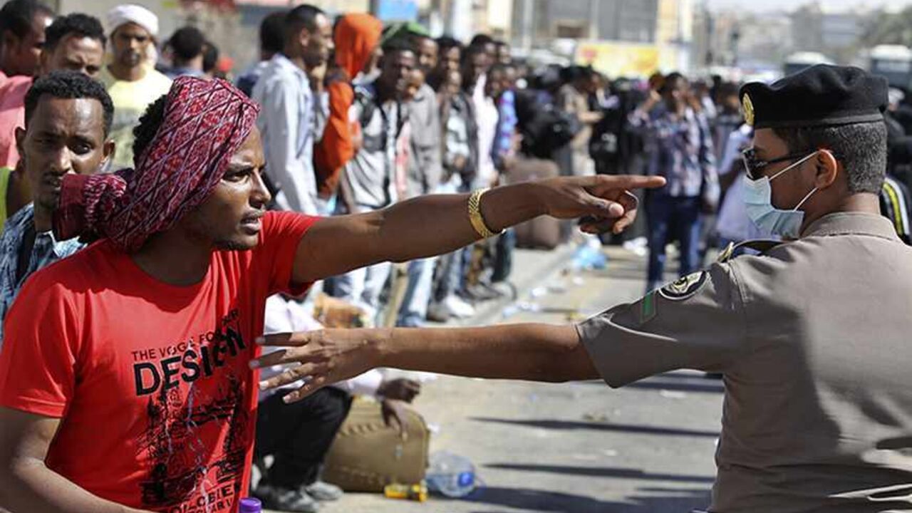 SAUDI-FOREIGNWORKERS/RIOT An Ethiopian worker argues with a member of the Saudi security forces as he waits with his countrymen to be repatriated in Manfouha, southern Riyadh, November 11, 2013. Thousands of mostly African workers gathered in Riyadh on Sunday seeking repatriation after two people were killed in overnight rioting that followed a visa crackdown by Saudi authorities. One of those killed was a Saudi, said a government statement, and the other was not identified. An Ethiopian man was killed in a visa raid last week. Ethi