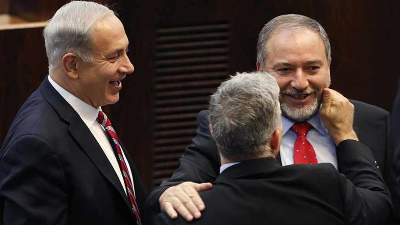 ISRAEL-POLITICS/LIEBERMAN Israel's Prime Minister Benjamin Netanyahu (L) and Finance Minister Yair Lapid (back to camera) congratulate Israeli far-right leader Avigdor Lieberman after he was sworn in as Israel's Foreign Minister at the parliament in Jerusalem November 11, 2013. Lieberman was sworn in as foreign minister on Monday after his acquittal on corruption charges, a development that could further complicate peace talks with the Palestinians. REUTERS/Amir Cohen (JERUSALEM - Tags: POLITICS TPX IMAGES OF THE DAY) - RTX159MP