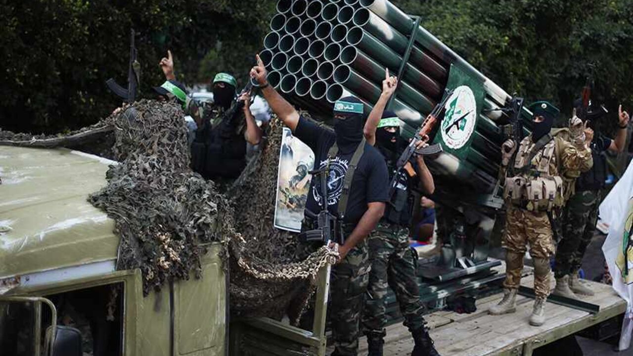 PALESTINIANS-ISRAEL/ Palestinian Hamas militants take part in a military parade marking the first anniversary of the eight-day conflict with Israel, in Gaza City November 14, 2013. Eight days of Israeli air strikes on Gaza and cross-border Palestinian rocket attacks in November last year ended in an Egyptian-brokered truce agreement calling on Israel to ease restrictions on the territory. REUTERS/Suhaib Salem (GAZA - Tags: POLITICS ANNIVERSARY CONFLICT MILITARY) - RTX15DDP
