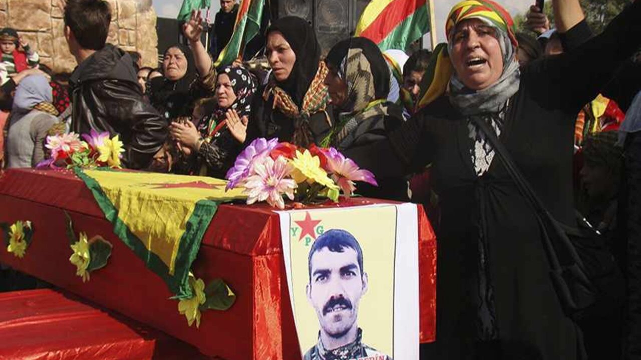 SYRIA-CRISIS A woman stands beside the coffin of a Kurdish People's Protection Units (YPG) soldier who died fighting the al-Qaeda linked Islamic State of Iraq and the Levant, and Islamist Syrian rebel group Jabhat al-Nusra in Qamishli November 14, 2013. Picture taken November 14, 2013. REUTERS/Massoud Mohammed (SYRIA - Tags: POLITICS CIVIL UNREST CONFLICT) - RTX15H58