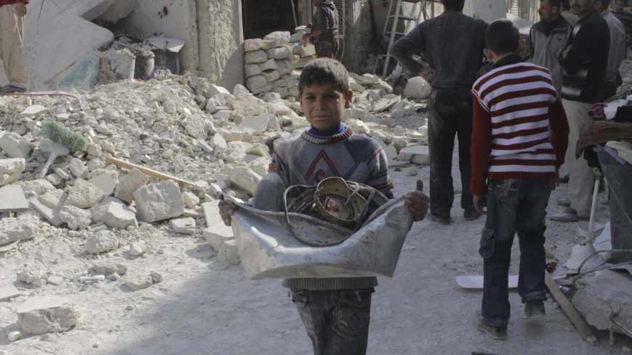 SYRIA-CRISIS/STRIKE A boy collects his belongings amidst the rubble of collapsed buildings after what activists said was shelling by forces loyal to Syria's President Bashar al-Assad in Aleppo November 24, 2013. Air strikes around the northern Syrian city of Aleppo killed at least 40 people on Saturday, most of them civilians, the Syrian Observatory for Human Rights said. REUTERS/Molhem Barakat (SYRIA - Tags: POLITICS CIVIL UNREST CONFLICT) - RTX15R6Q