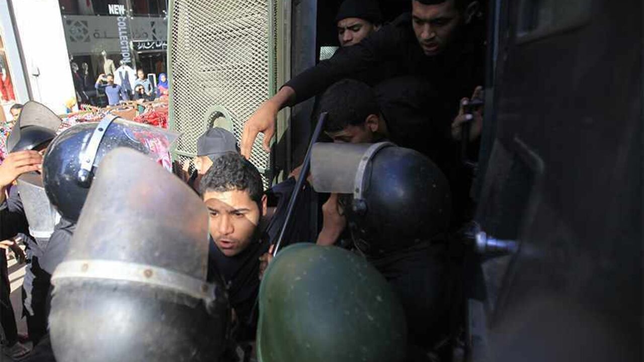 EGYPT-PROTEST/ Riot police detain a man, who was protesting against a new law restricting demonstrations, in downtown Cairo November 26, 2013. Egyptian police fired a water cannon to disperse dozens of protesters near the Ministry of Interior on Tuesday after they defied the new law that restricts demonstrations. REUTERS/Amr Abdallah Dalsh (EGYPT - Tags: POLITICS CIVIL UNREST) - RTX15TTK