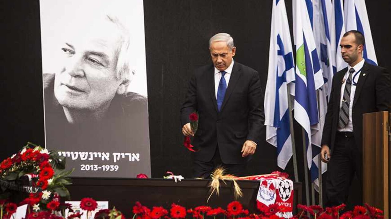 ISRAEL-EINSTEIN/ Israeli Prime Minister Benjamin Netanyahu (C) lays a rose on the coffin of Israeli singer Arik Einstein, depicted in the placard, during a memorial ceremony before his funeral at Rabin square in Tel Aviv November 27, 2013. For many Israelis, nothing symbolised home more than singer Einstein, and on Wednesday a nation mourned the death of its king of cool. Einstein died of a ruptured aneurysm on Tuesday night at the age of 74. REUTERS/Nir Elias (ISRAEL - Tags: ENTERTAINMENT OBITUARY SOCIETY) - RTX15UZ9