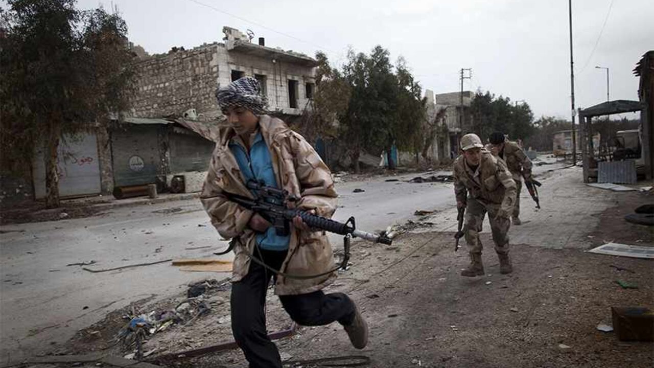 Nic6181646 TO GO WITH AFP STORY BY ANTONIO PAMPLIEGA
Syrian Turkmen rebels run across a street controlled by regime forces to dodge sniper fire in the Hanano district of the northern city of Aleppo on January 28, 2013. Members of Syria's Turkmen minority have joined forces with rebels fighting President Bashar al-Assad's regime in a struggle they say is for democracy and revenge for years of oppression. AFP PHOTO/JM LOPEZ (Photo credit should read JM LOPEZ/AFP/Getty Images)