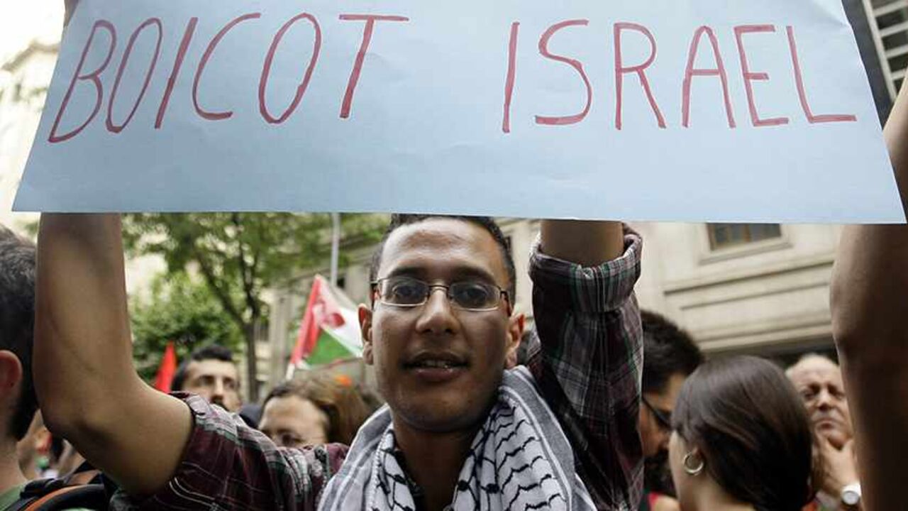 PALESTINIANS-ISRAEL/REACTION/ Demonstrators shout slogans as a man shows a banner which reads "boycott Israel" during an anti-Israel protest in front of Chamber of Commerce Israel-Catalunya in Barcelona May 31, 2010. Israeli marines stormed a Turkish aid ship bound for Gaza on Monday and 10 pro-Palestinian activists were killed, triggering a diplomatic crisis and plans for an emergency session of the U.N. Security Council. REUTERS/Albert Gea (SPAIN - Tags: POLITICS CIVIL UNREST) - RTR2ELSN