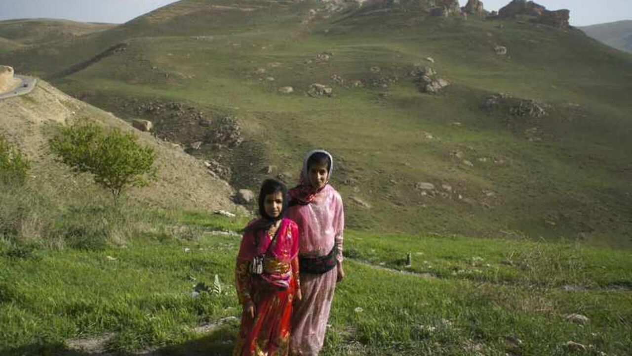 Iranian Sunni Kurd women wearing traditional clothes pose for photograph as they stand in Caraftoo cave historical site in Divandare Two Iranian Sunni Kurd women wearing traditional clothes pose for a photograph as they stand in the Caraftoo cave historical site in Divandare, Kurdistan province, 540 km (338 miles) west of Tehran May 13, 2011. Iranian Shi'ite and Sunni Kurds live in harmony with each other in Divandare, although Sunni is the religion of the majority of the people. REUTERS/Morteza Nikoubazl (IRAN - Tags: TRAVEL SOCIETY RELIGION) - RTR2MDZX