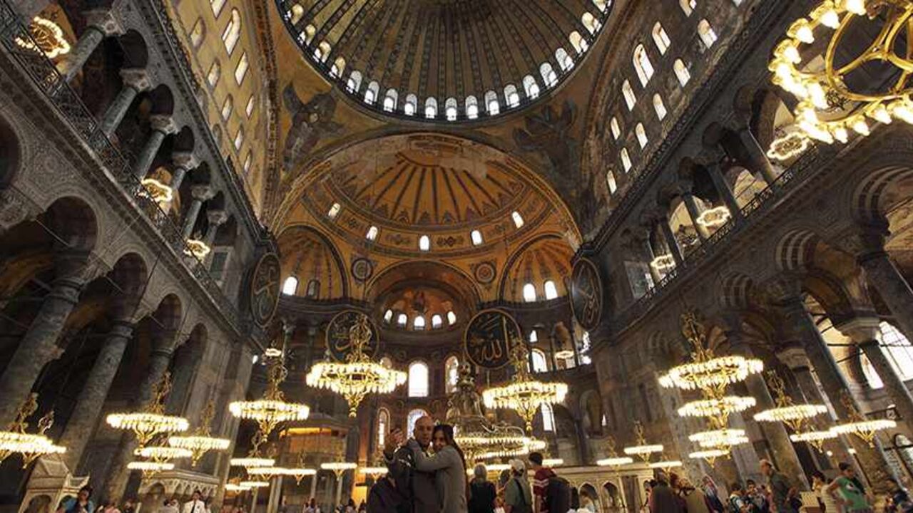 TOURISM-TURKEY/ A Macedonian couple (C) takes souvenir pictures as they visit the Byzantine monument of Hagia Sophia or Ayasofya, now a museum, in Istanbul May 25, 2011. The number of foreign visitors to Turkey rose 31.3 percent year-on-year in April to 2.29 million people, the Tourism Ministry said on Wednesday, after climbing 14.36 percent in March. Last year, the number of visitor arrivals rose 5.74 percent to 28.6 million. REUTERS/Murad Sezer (TURKEY - Tags: TRAVEL SOCIETY) - RTR2MVLK