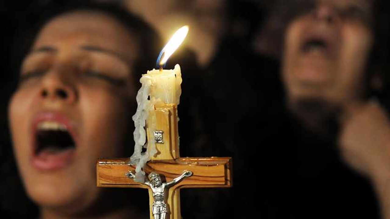 EGYPT-ELBARADEI Egyptian Coptic Christians carry a cross and chant prayers during a candlelight protest marking one week since sectarian clashes with soldiers and riot police at a protest against an attack on a church in southern Egypt, at Abassaiya Cathedral in Cairo October 16, 2011. Egyptians detained in connection with clashes between Christian protesters and military police that left 25 people dead should be tried in civilian not military courts, presidential candidate Mohamed ElBaradei said on Sunday. REUTERS/Stringe