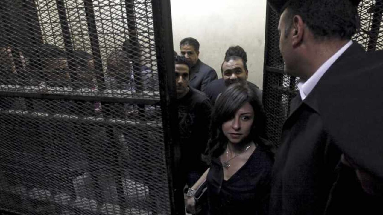 Activists, accused of working for unlicensed NGOs and receiving illegal foreign funds, stand in a cage during the opening of their trial in Cairo Activists, accused of working for unlicensed non-governmental organizations (NGOs) and receiving illegal foreign funds, stand in a cage during the opening of their trial in Cairo March 8, 2012. An Egyptian judge said on Thursday he was delaying until April 10 the trial of civil society activists including 16 Americans accused of receiving illegal foreign funds and pursuing their pro-democracy activities without a licence. REUTERS/Mohamed Abd El Ghany (EGYPT - Tags: CIVIL UNREST POLITICS CRIME LAW) - RTR2Z1