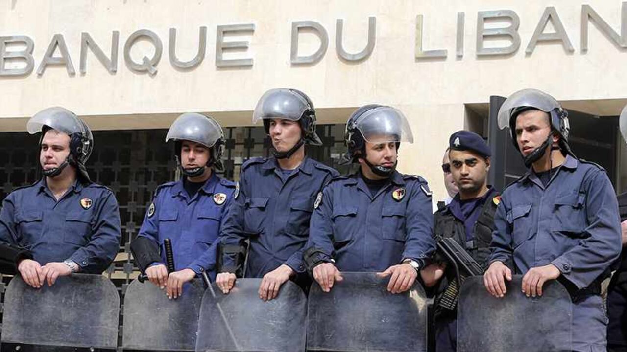 LEBANON/ Lebanese riot police stand guard at the Lebanese Central Bank in Beirut February 25, 2013. An open-ended strike by teachers and civil servants entered its second week today for the government to approve the wage hike proposal. REUTERS/Mohamed Azakir (LEBANON - Tags: POLITICS CIVIL UNREST) - RTR3E9U4